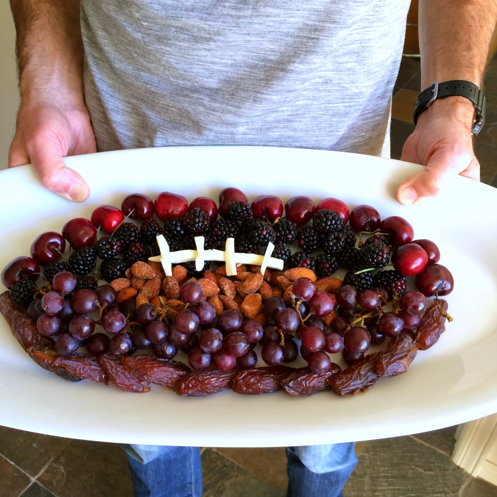 Man holding a Fruit Football on a white platter on ShockinglyDelicious.com