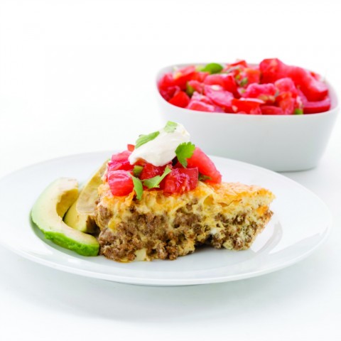 Easy Taco Pie on a white plate with pico de gallo on top and in a bowl behind it