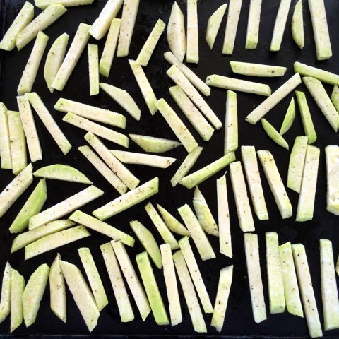 Kohlrabi fries lined up on the baking sheet