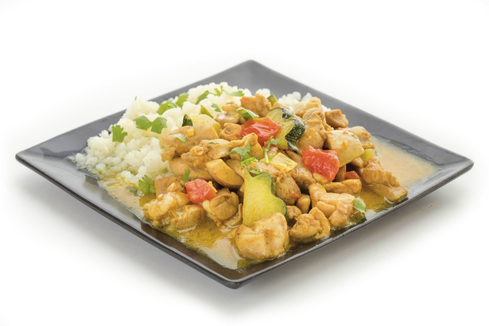 Chicken Coconut Curry on rice on a black plate