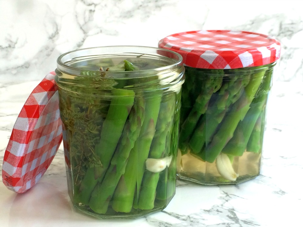 2 jars of Refrigerator Pickled Asparagus on a white marble background on ShockinglyDelicious.com