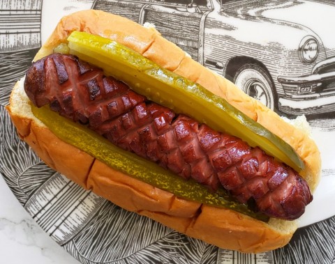 Crosshatch cut on a hot dog in a bun on a decorated plate