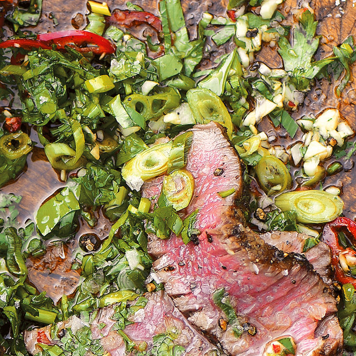 Filet mignon slices mingle with herbs on a wooden board for Cutting Board Sauce