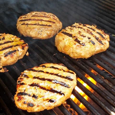 Island Pork Burgers ready on the grill on ShockinglyDelicious.com