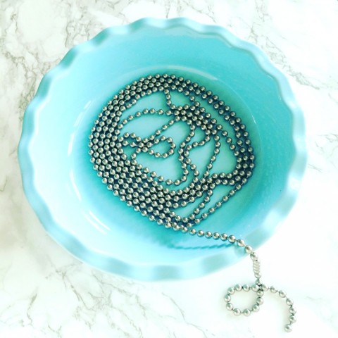 Pie weight chain coiled in a turquoise pie dish