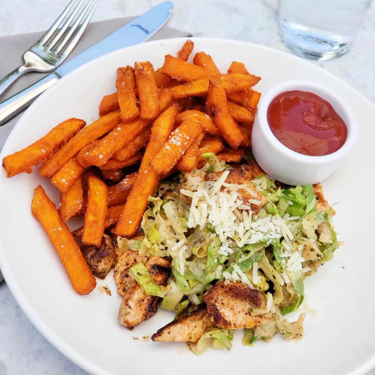 Salmon Salad on a white plate with sweet potato fries alongside and a small white bowl of ketchuphe wrap at the Sparrow Cafe in Malibu California