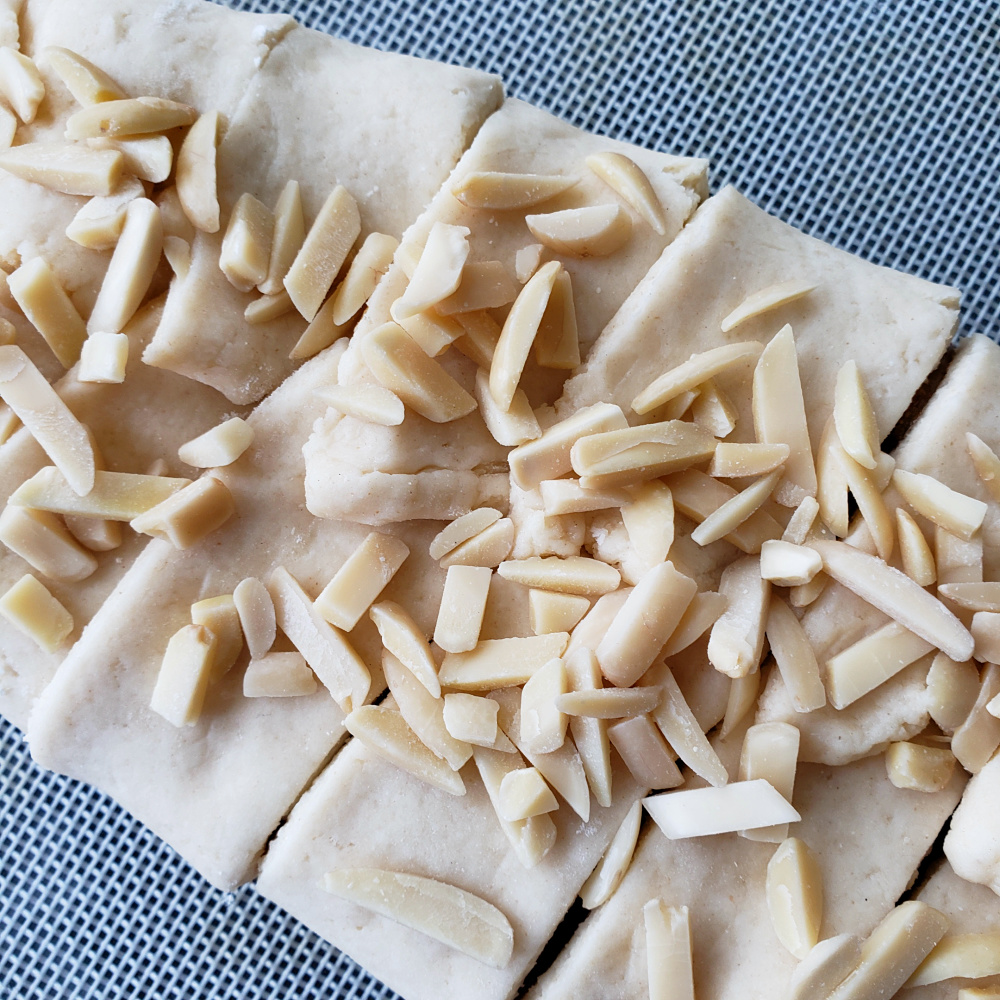 Closeup of slivered almonds on top of Cream Cheese Pastry with Almond Filling before baking