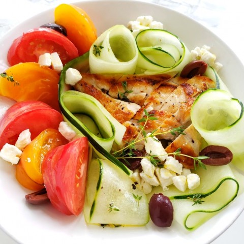 Chicken, Tomato and Cucumber Dinner Salad in a white bowl on a white marble counter