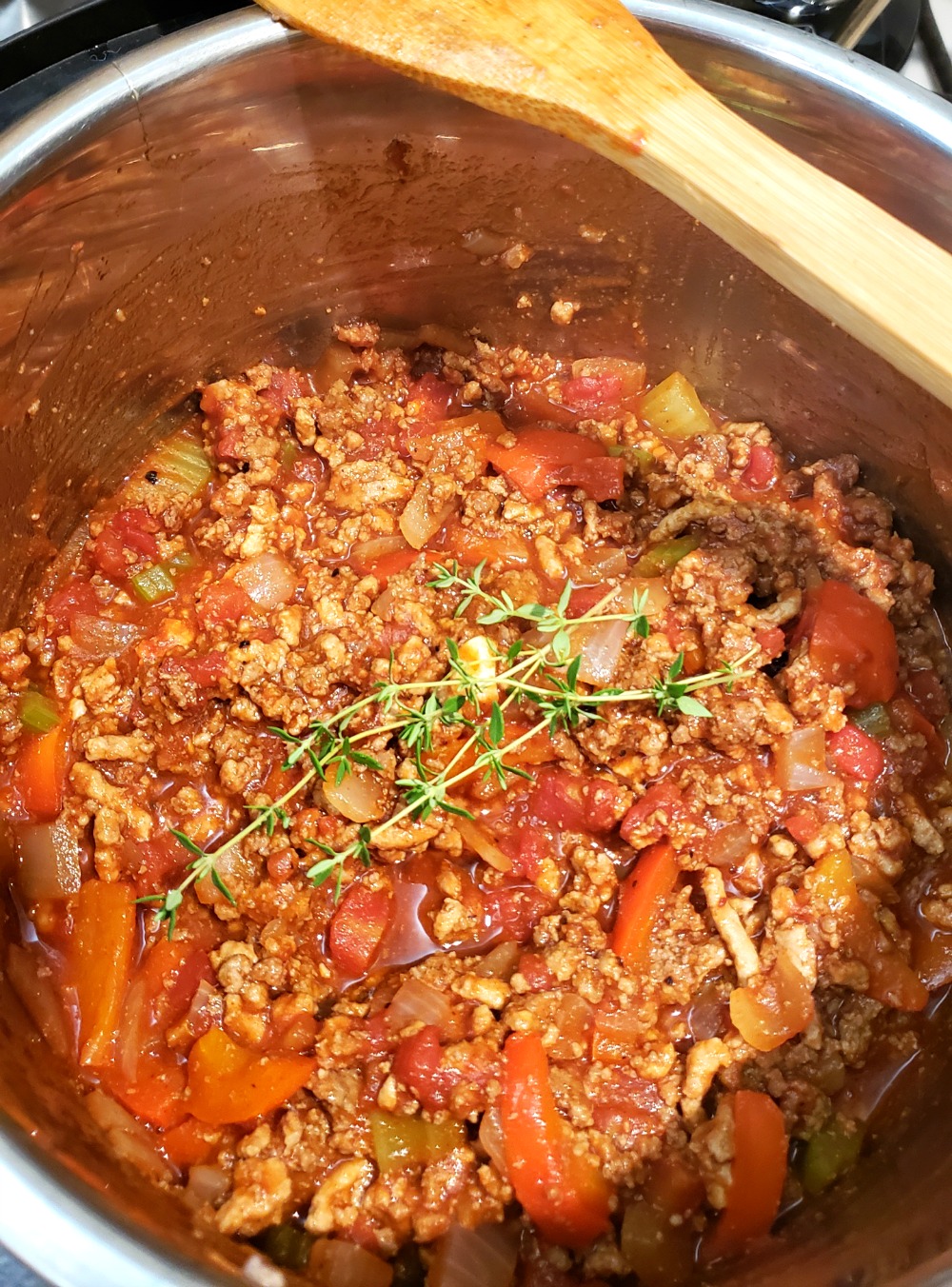 Thyme sprig on top of meat mixture in the Instant Pot