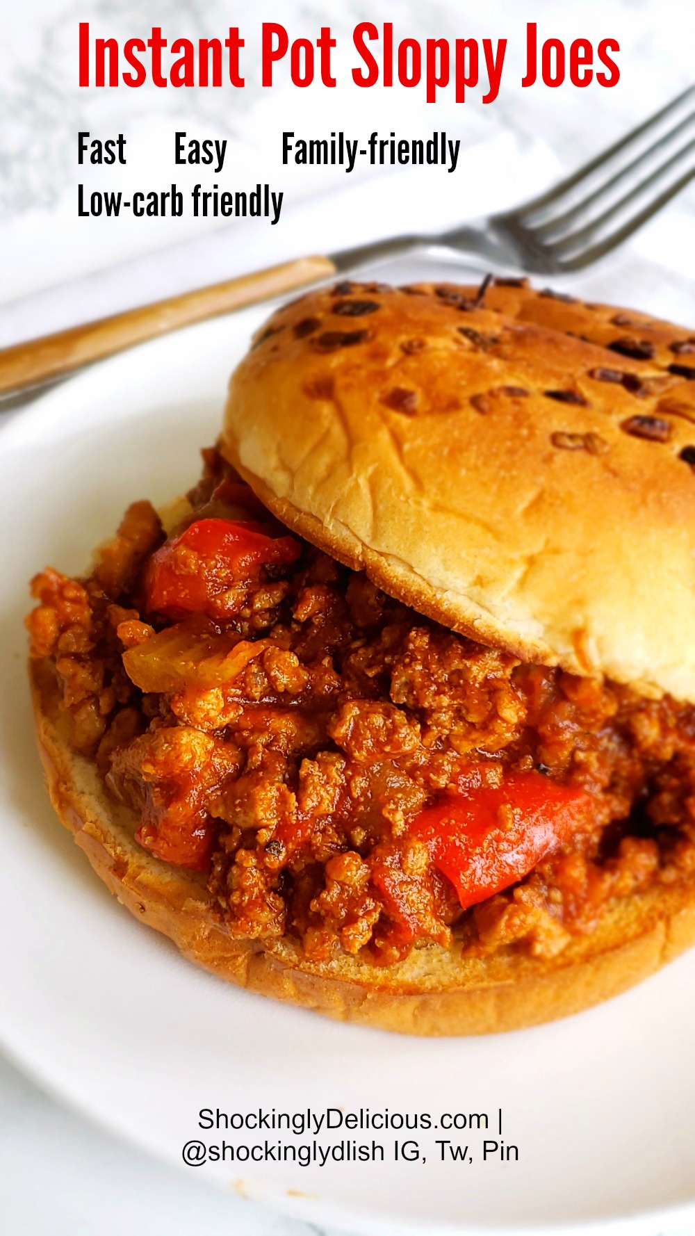 Instant Pot Sloppy Joes on a bun on a white plate with fork alongside