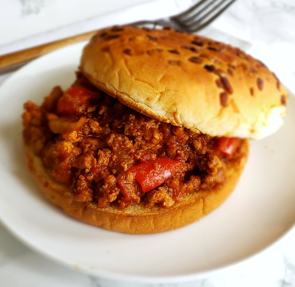 Simple Instant Pot Sloppy Joes on a bun on a white plate on ShockinglyDelicious.com