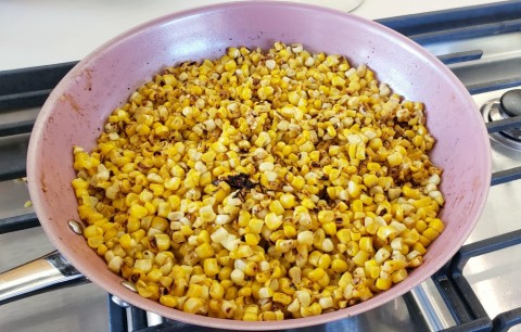 Corn toasting in the skillet for Esquites on ShockinglyDelicious.com