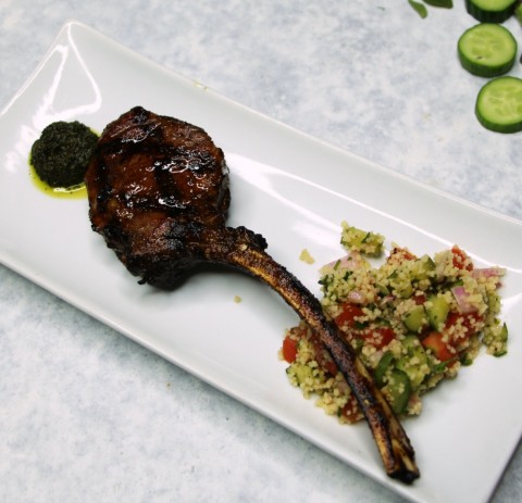 Piruleta de cordero con cuscús marroquí y pesto a la menta en un plato blanco rectangular en ShockinglyDelicious.com