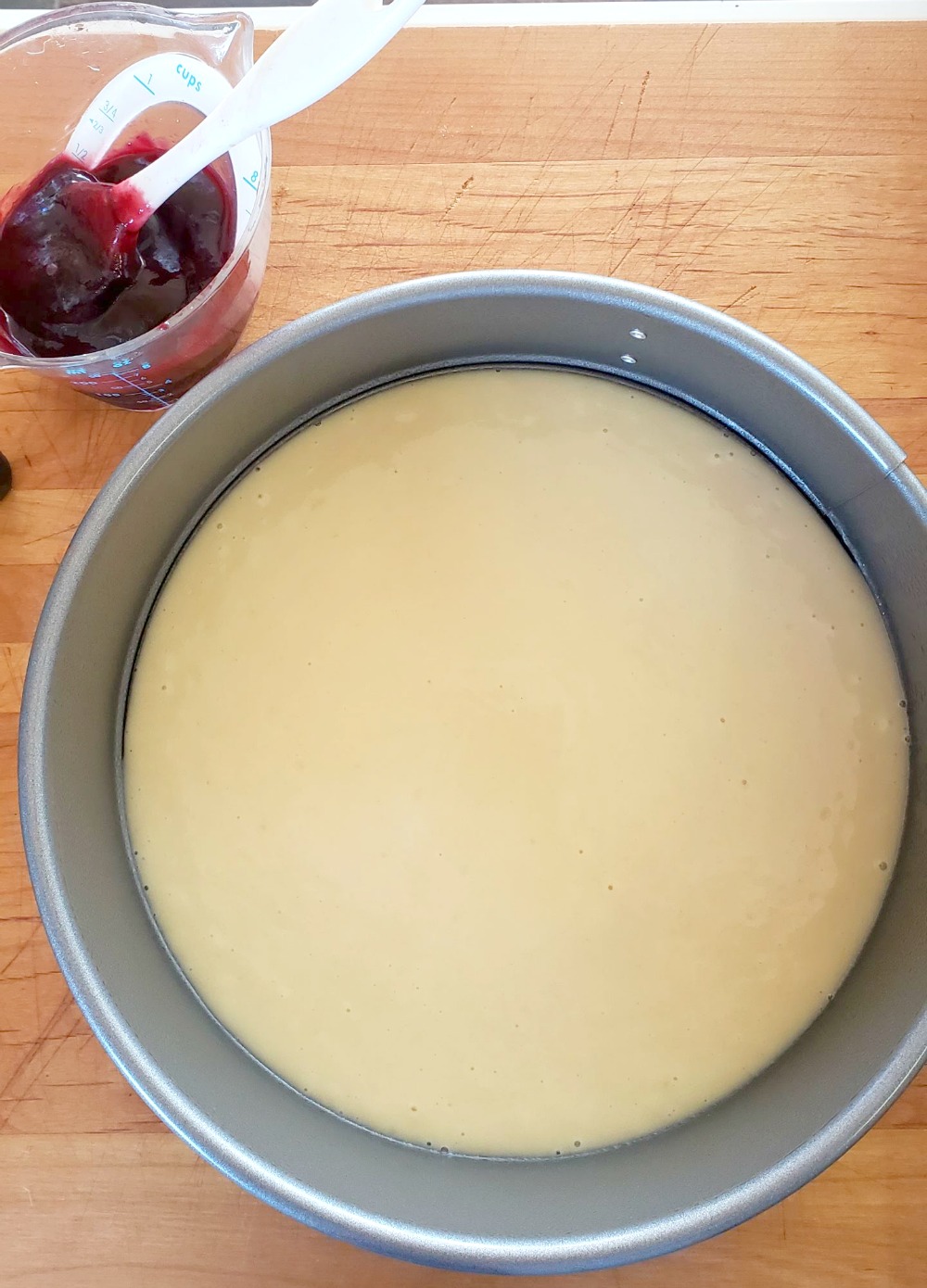 Beige batter in silver metal pan for Jam Breakfast Cake with Streusel on ShockinglyDelicious.com