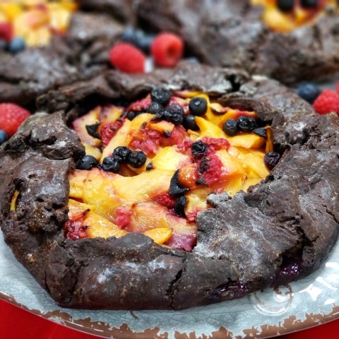 Easy Fruit Galette with a Chocolate Crust: An explosion of summer fruits in a dark chocolate crust, this easy, not-too-sweet fruit tart is the perfect dessert after a meal. You don't even need a tart pan or pie plate! This is a wonderful Paula Shoyer recipe from 