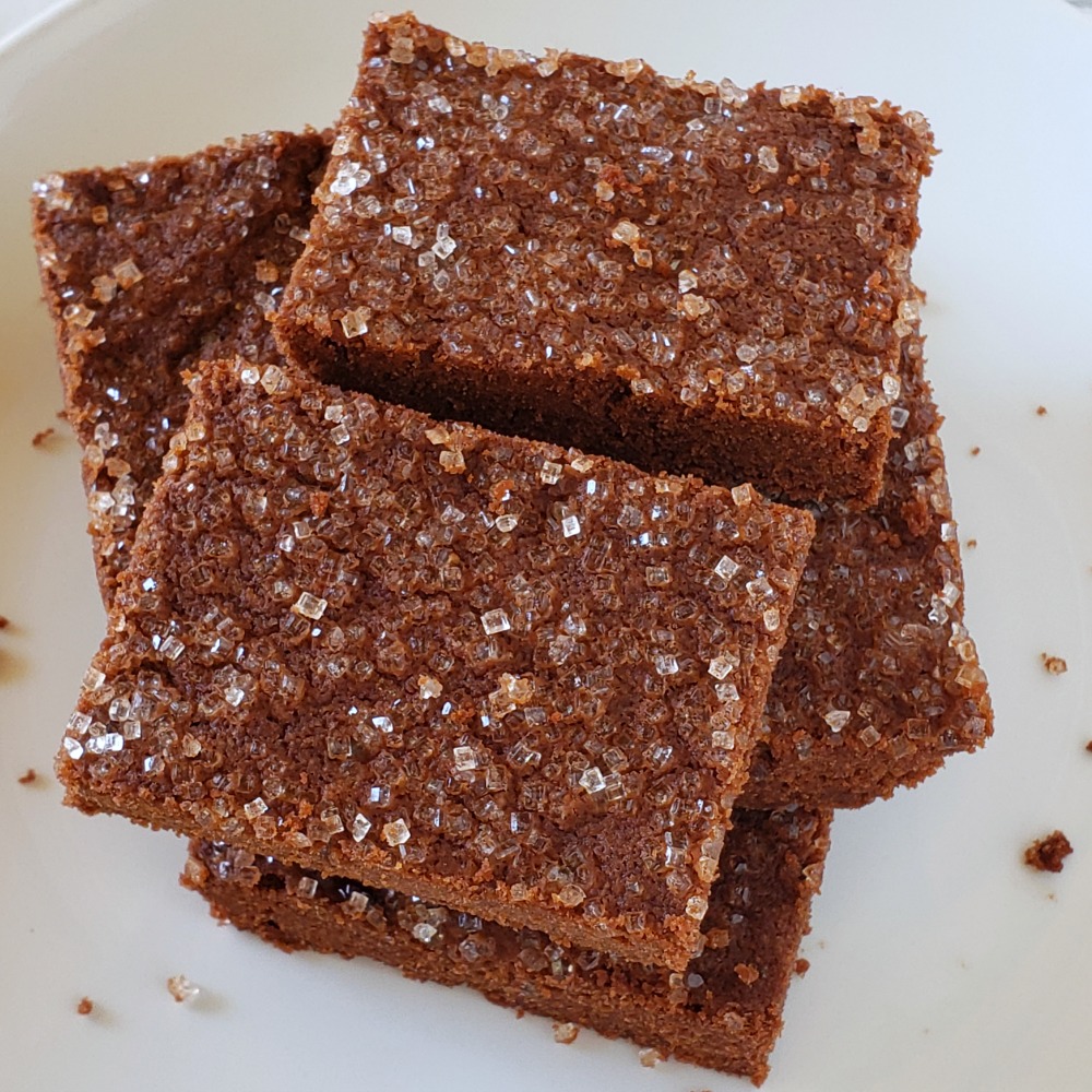 Squares of Rich Chocolate Shortbread stacked on a white plate on ShockinglyDelicious.com