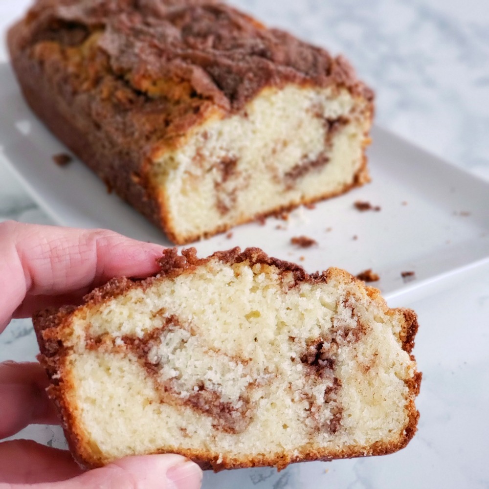 Hand holding a slice of Cinnamon Swirl Quick Bread