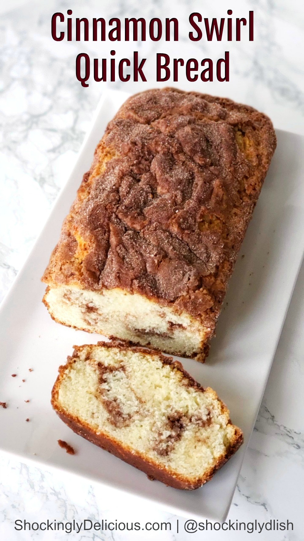 Cinnamon Swirl Quick Bread on a white plate, on a white marble counter