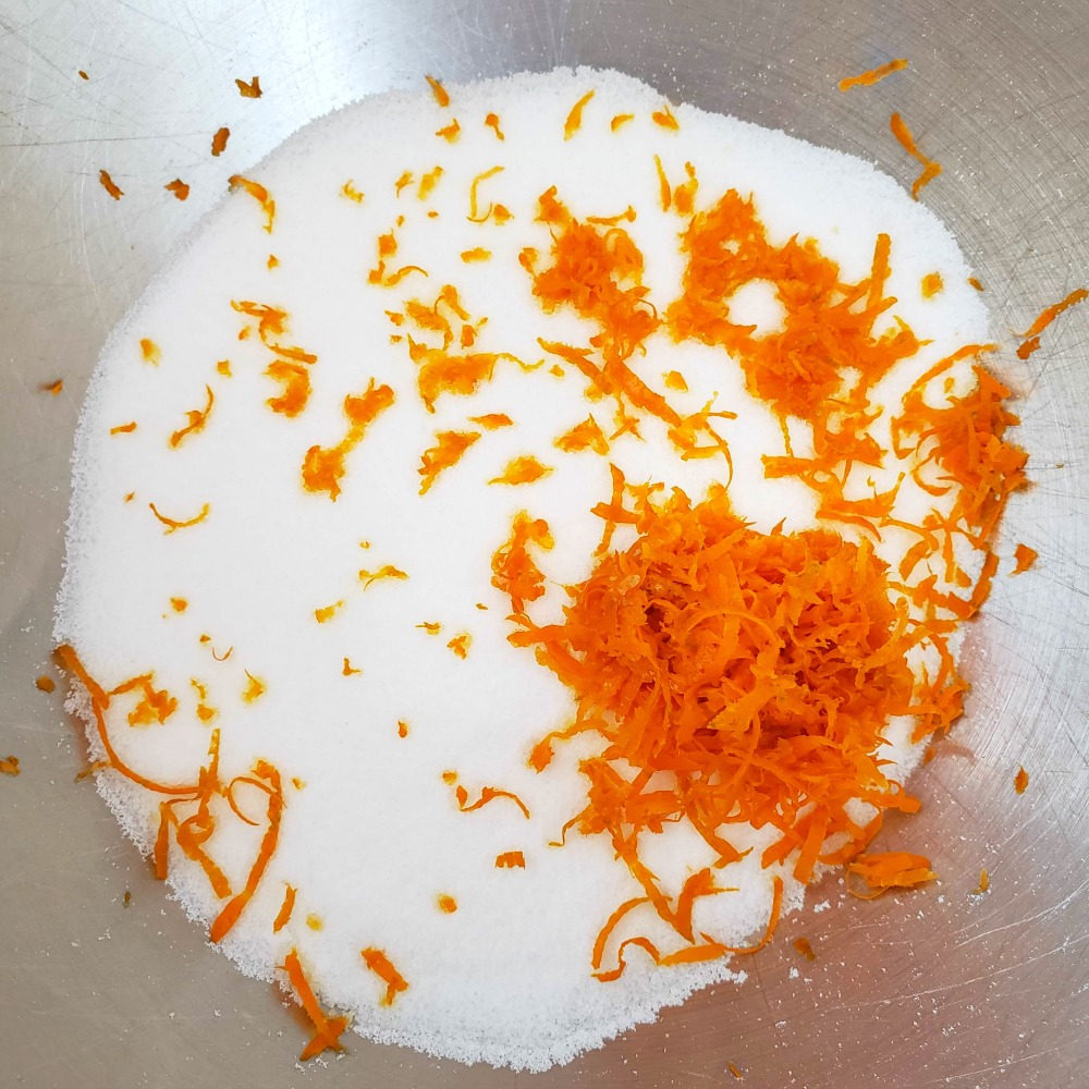 tangerine rind and sugar in a silver mixing bowl