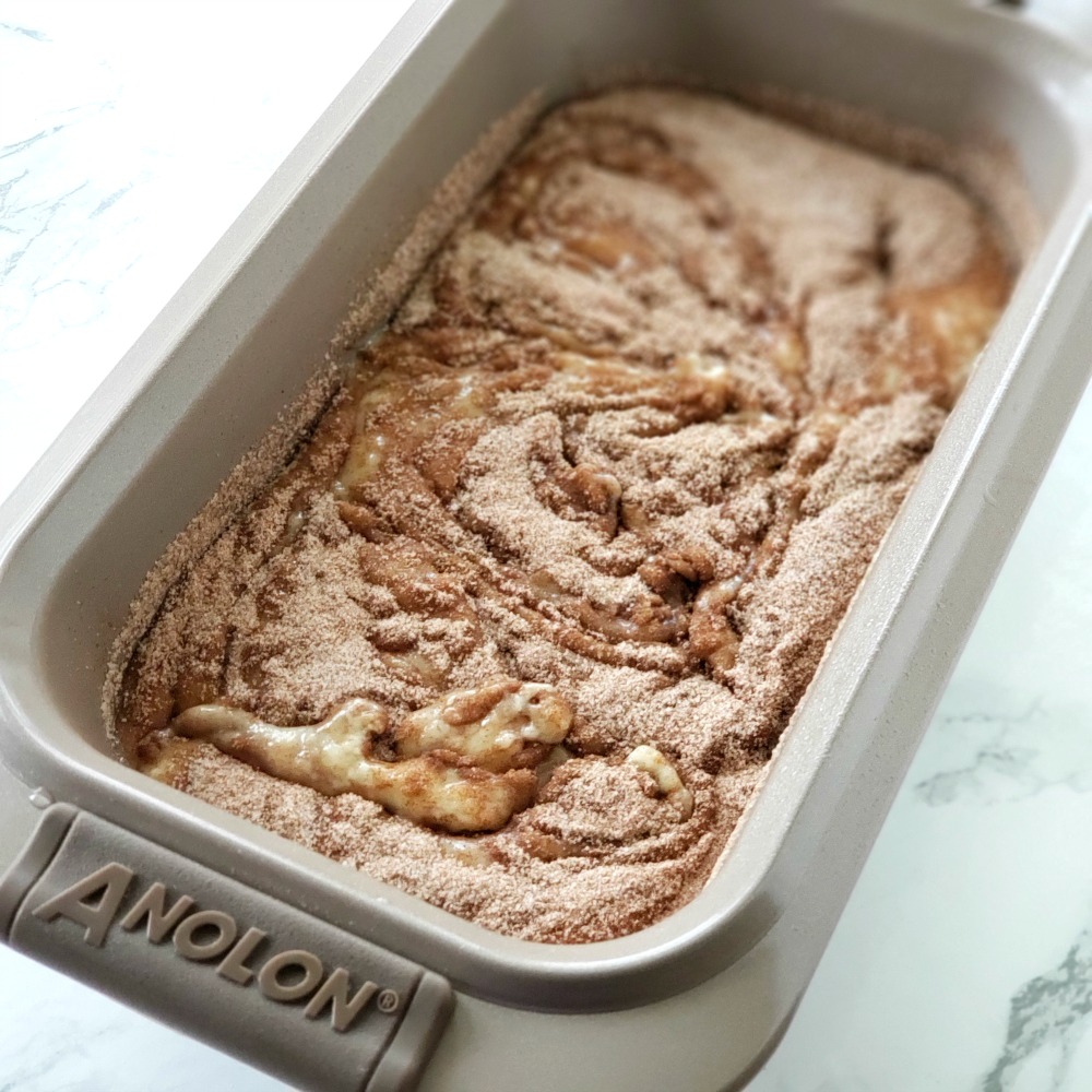 Cinnamon sugar swirled into the quick bread in a pan ready to bake