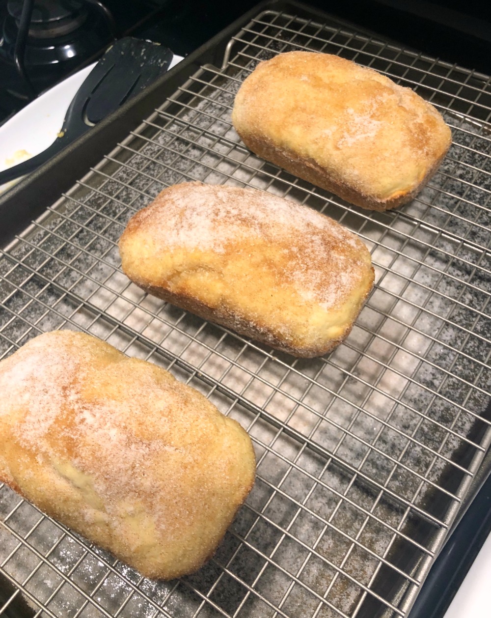 Cinnamon Doughnut Muffins made into mini loaves 3 mini loaves of Cinnamon Doughnut Muffins made into bread loaves, on a cooling rack.