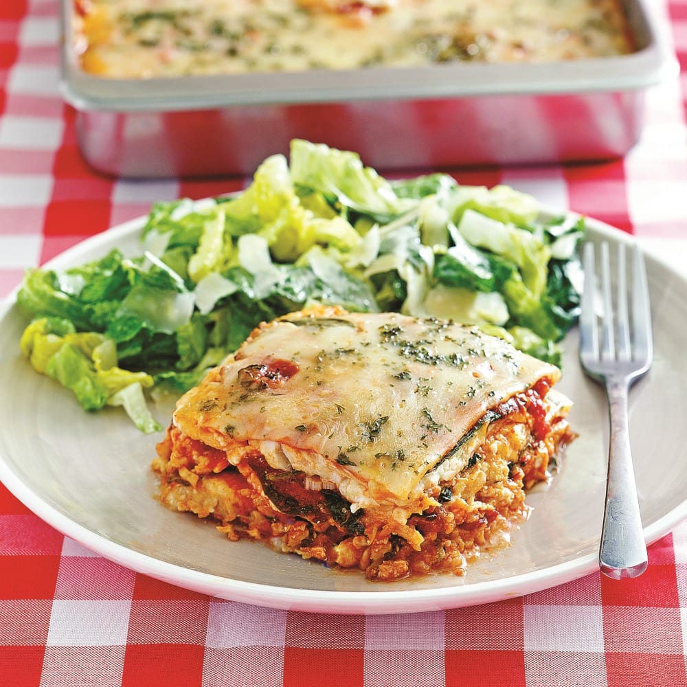 Keto Lasagna on a white plate with a green salad