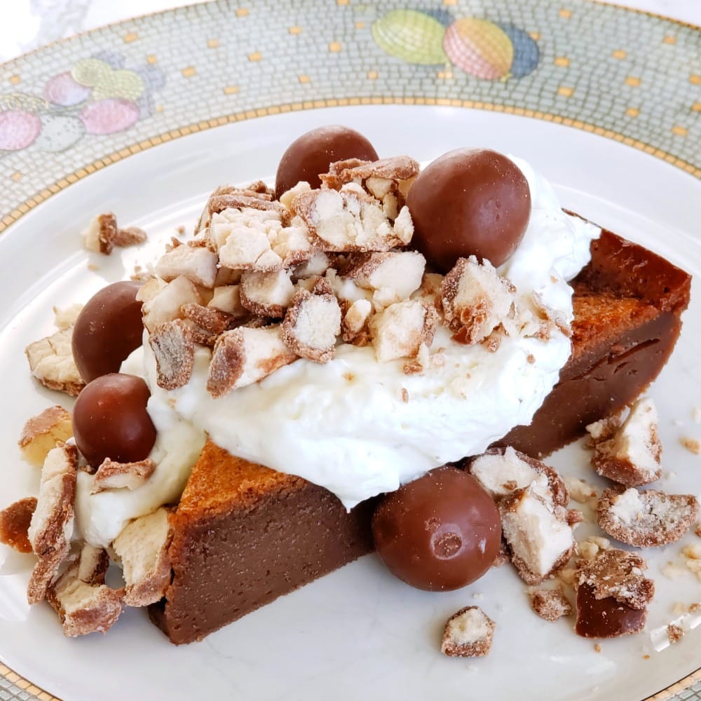 Chocolate Impossible Pie with Whipped Cream and Whoppers on top on ShockinglyDelicious.com