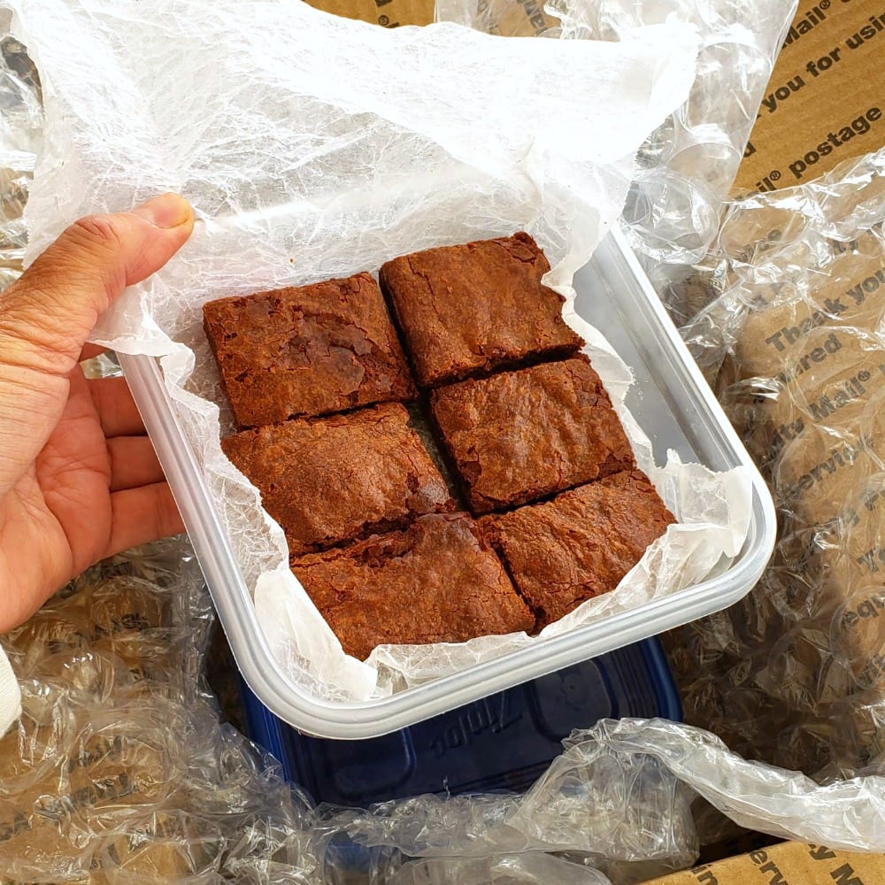 Fudgy Chocolate Brownies packed into a plastic container for shipping