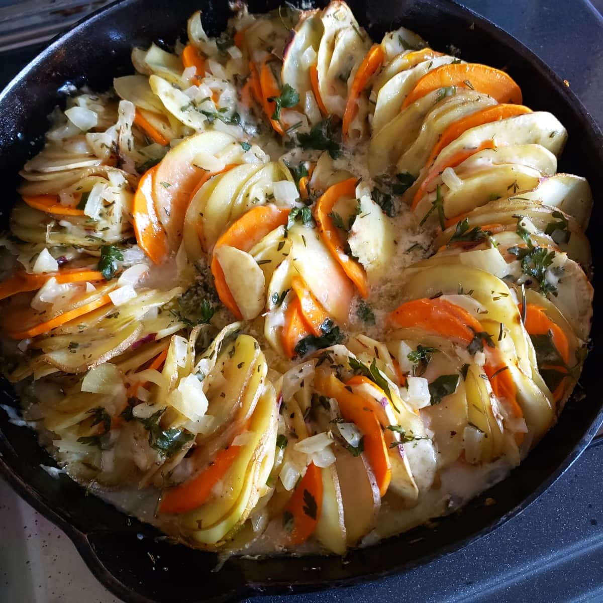 Cheese Herb Potato Gratin in a cast iron skillet baked and out of the oven