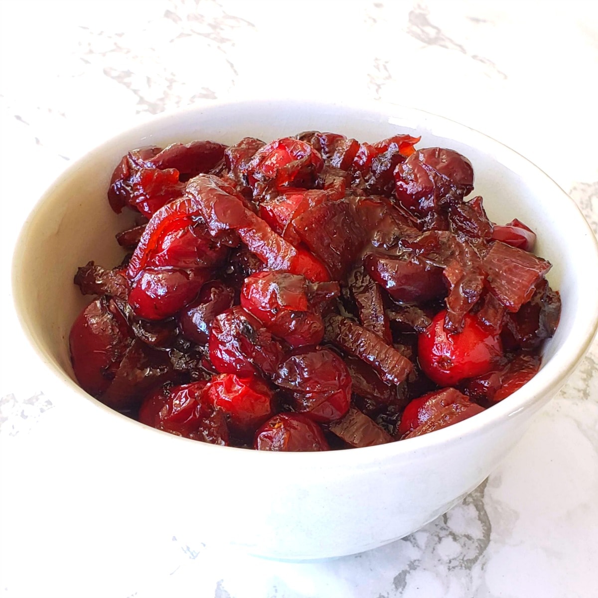 Cranberry Sauce with Caramelized Onions in a small bowl on a marble countertop