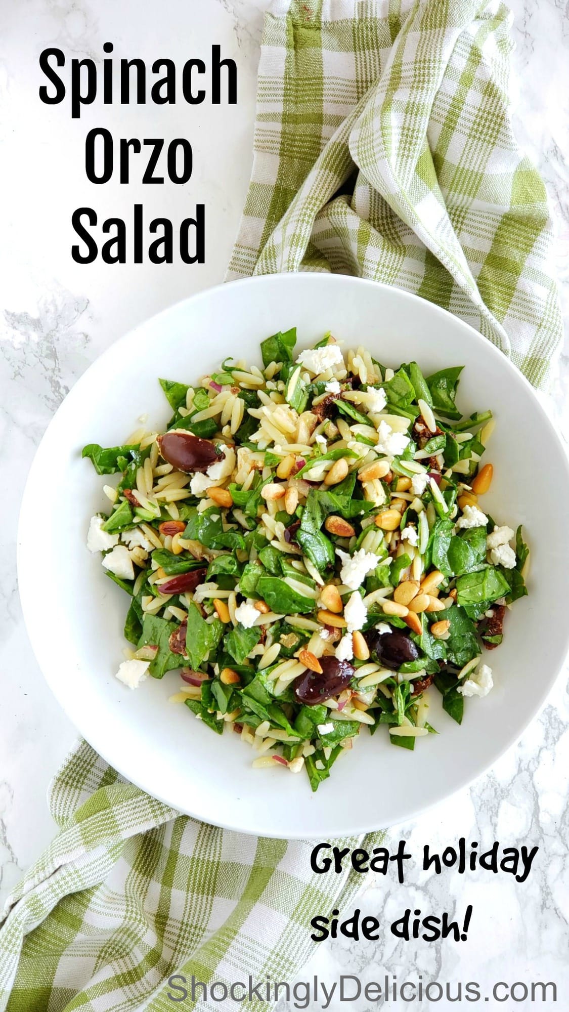 Easy Spinach Orzo Salad in a white bowl sitting on a green plaid dish towel on ShockinglyDelicious.com