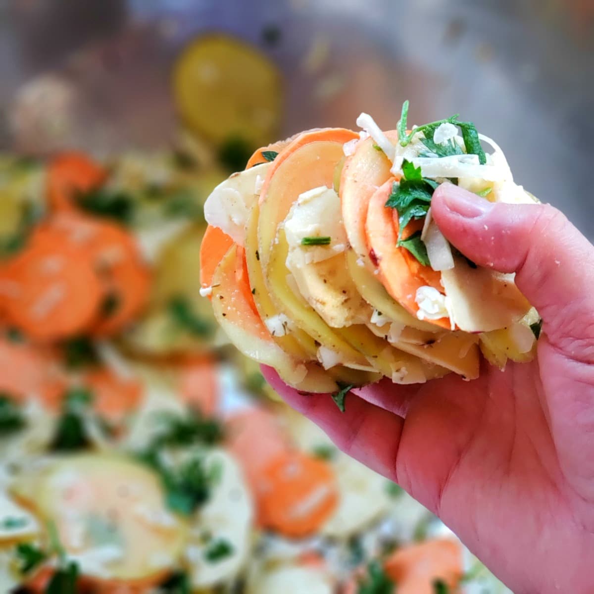 Hand holding a stack of thinly sliced potatoes