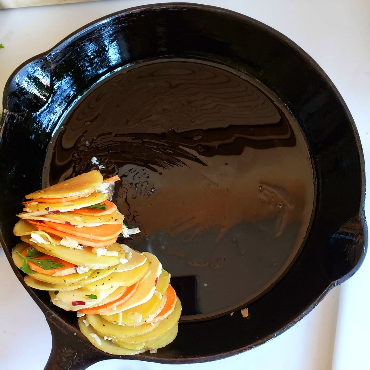 Place a stack of potatoes in the oiled skillet