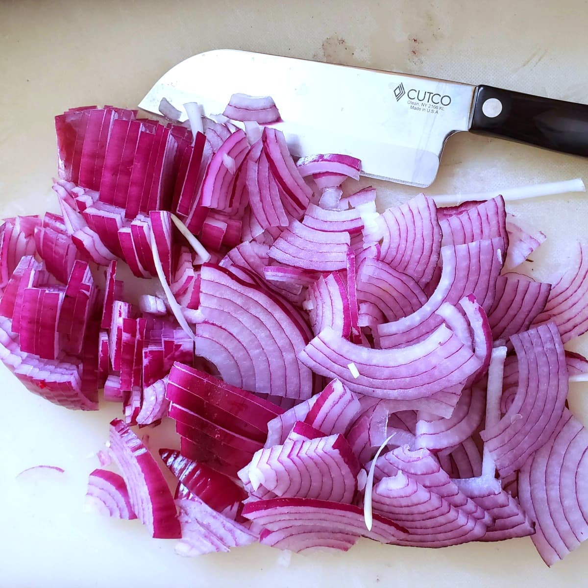 Slicing red onions on a cutting board