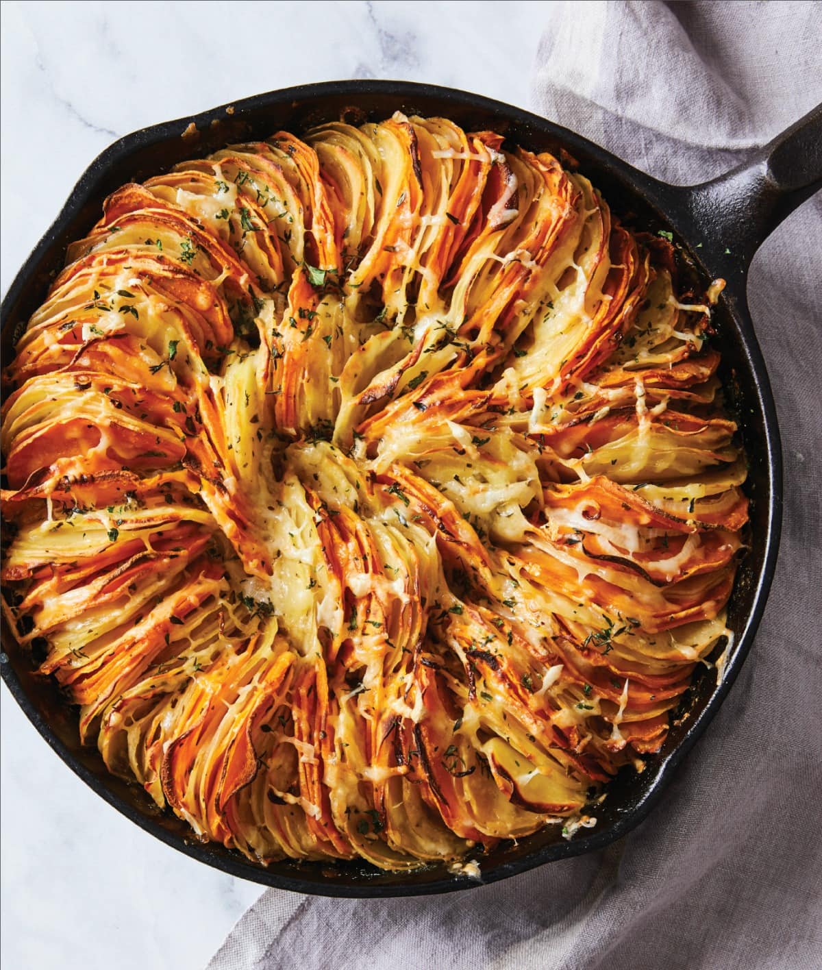 Cheese Herb Potato Gratin is the impressive side dish you'll want for the holidays, but can eat all year long. Impossibly thin leaves of potatoes stack sideways in a skillet with herbs and cheese for a deeply satisfying, comforting dish.