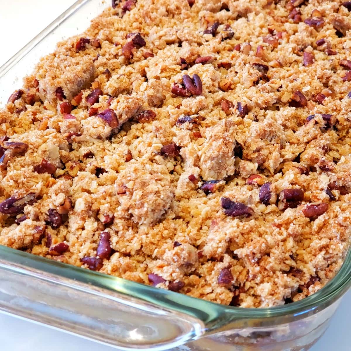 Glass baking dish full of Pumpkin Pie Bars with Oat Crumble Topping on ShockinglyDelicious.com