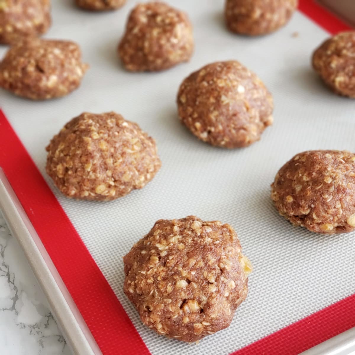 Cookie balls on a Silpat-lined baking sheet