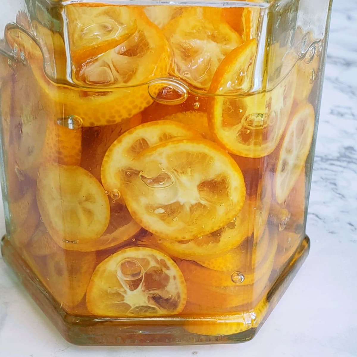 Sliced kumquats and honey in a jar getting candied