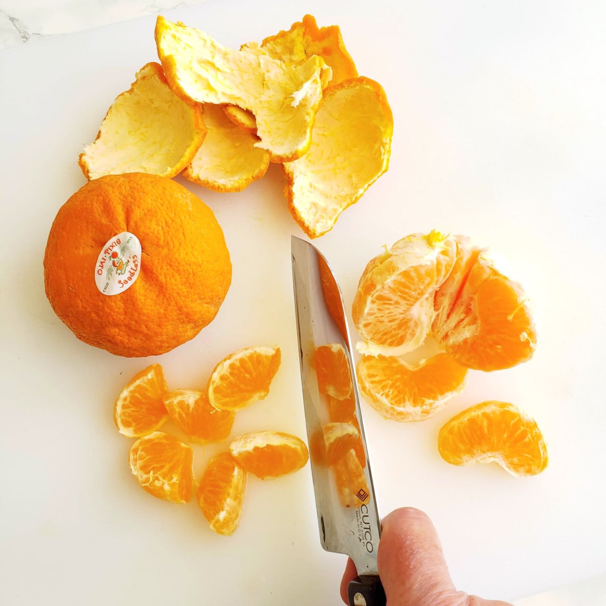 Peel, segment and cut the tangerines on a white cutting board