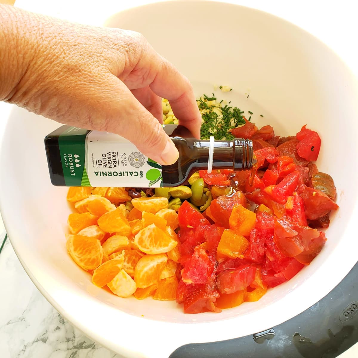 Pour in olive oil over the vegetables in a white bowl