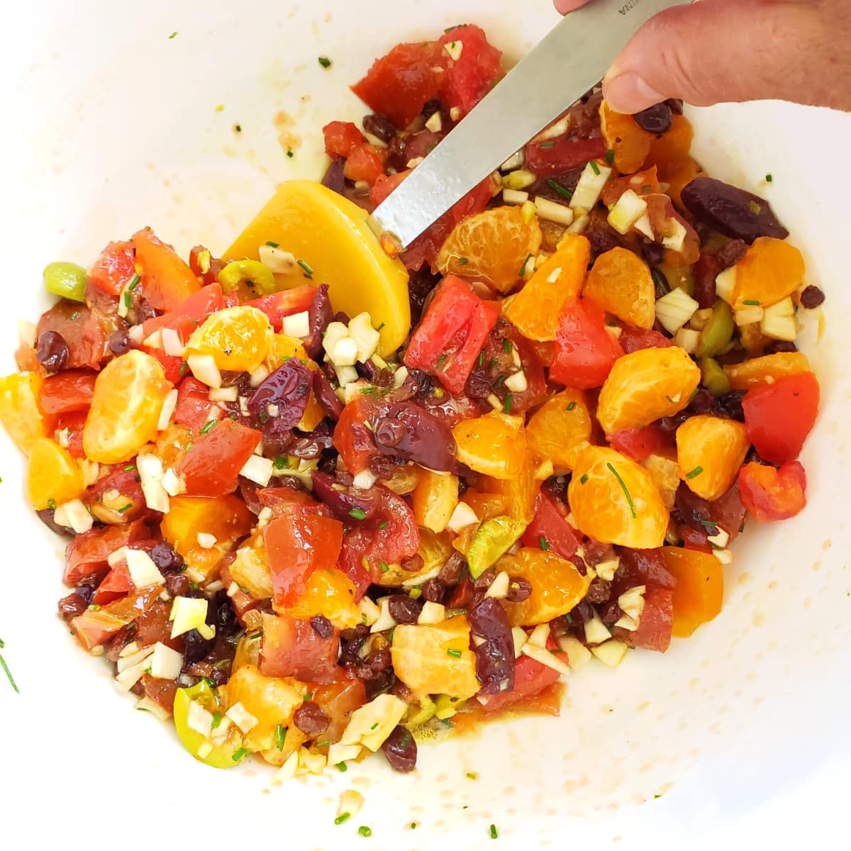 Stir the Tomato and Tangerine pasta sauce in a white cutting bowl