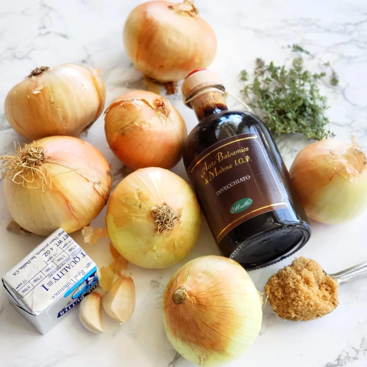 Ingredients for French Onions on a white marble counter on ShockinglyDelicious.com