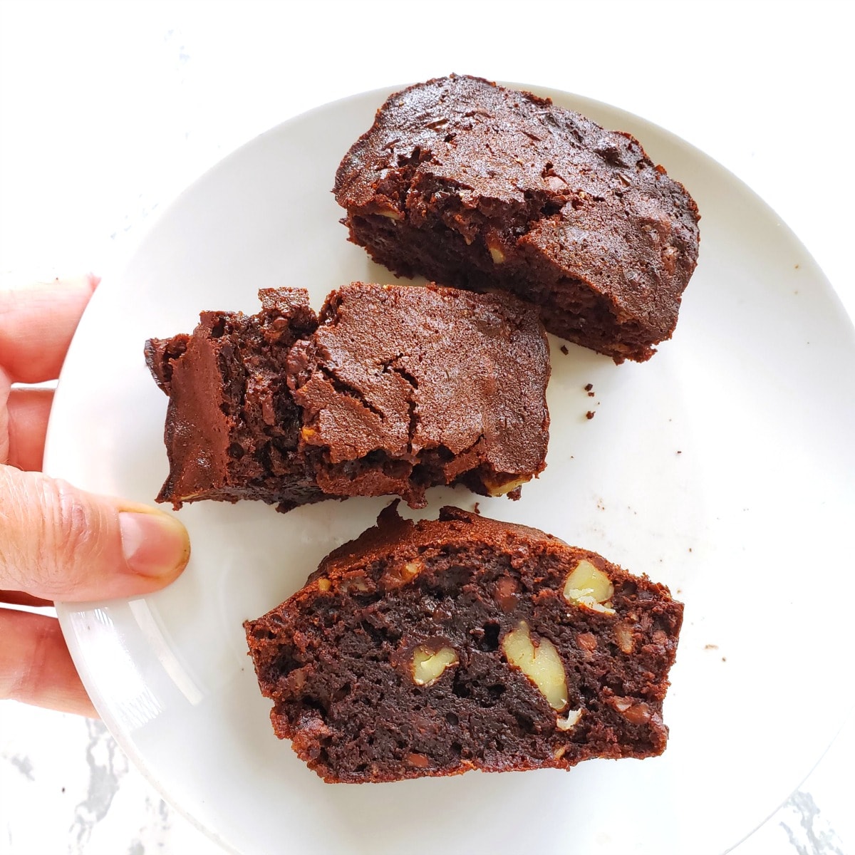 Small Batch Emergency Brownies on a white plate held by a hand