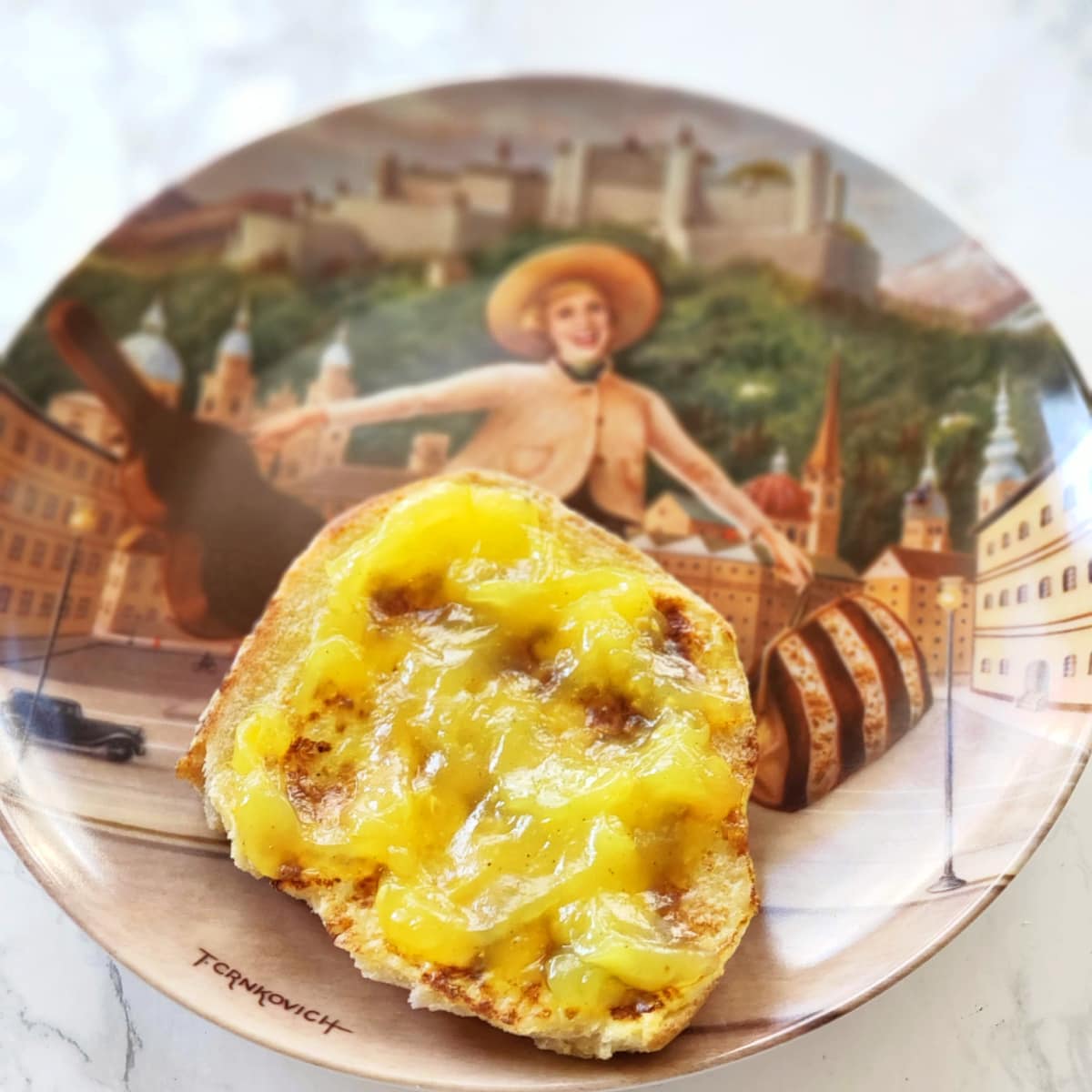 Lemon Filling on an English muffin on a Sound of Music plate on a white marble counter 