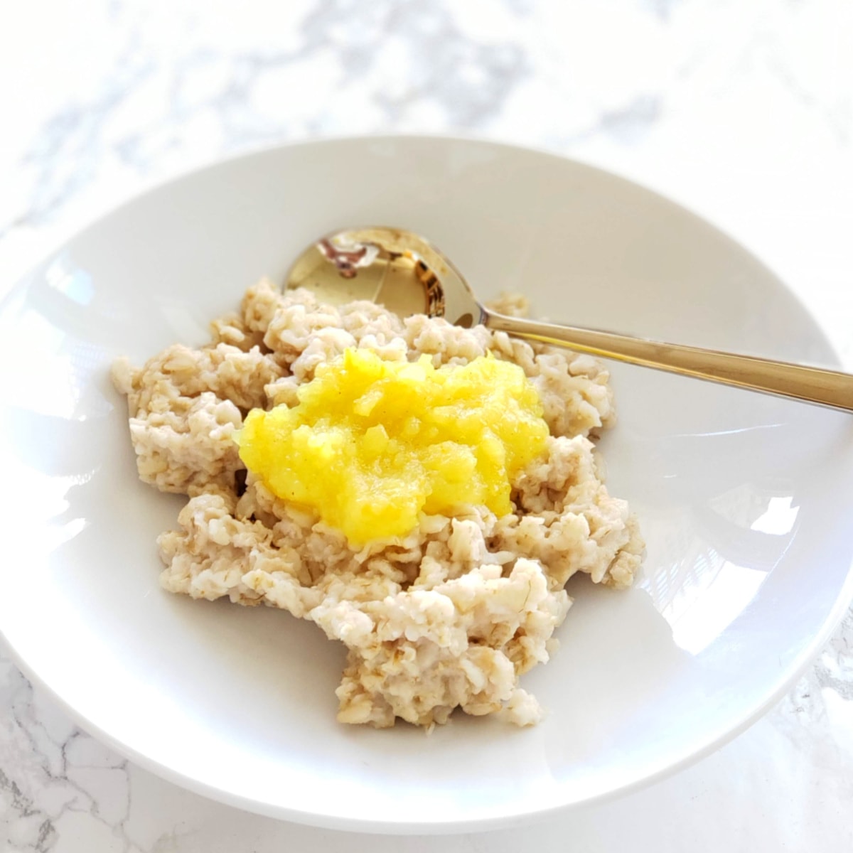 Lemon Filling on top of a white bowl of oatmeal on a white marble counter on ShockinglyDelicious.com