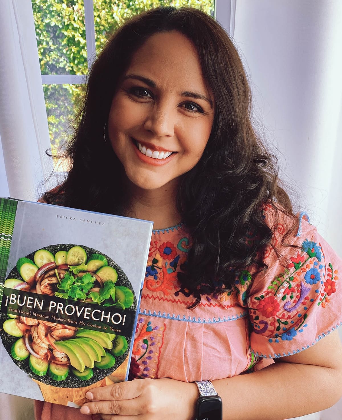 Author Ericka Sanchez holds her new cookbook Buen Provecho