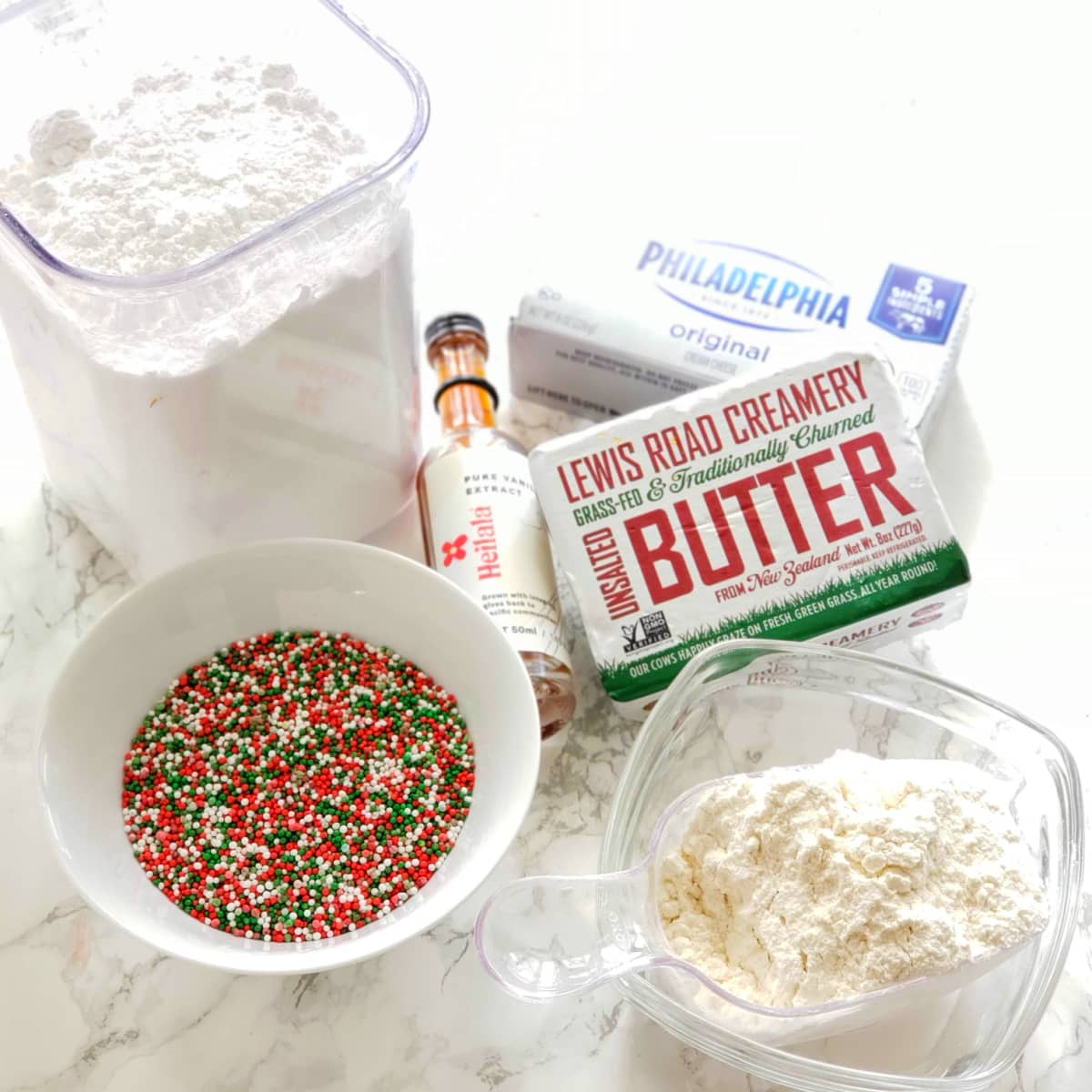 Ingredients for Cream Cheese Sprinkle Cookies on a white marble counter on ShockinglyDelicious.com