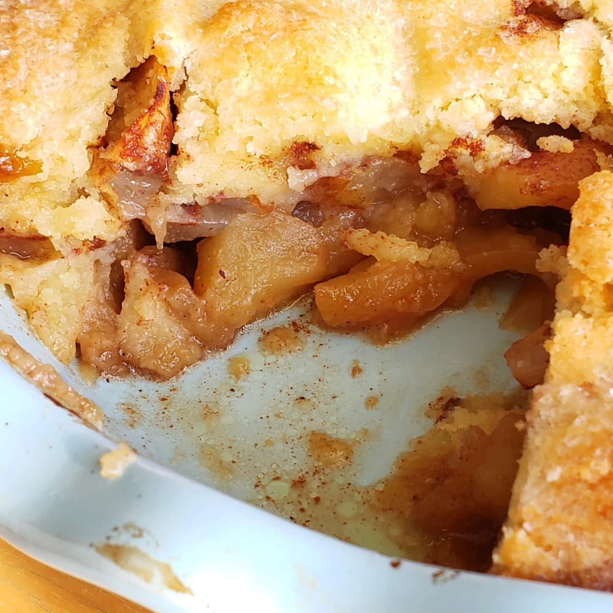 Light blue pie dish with cut pie showing inside a Swedish Apple Pie