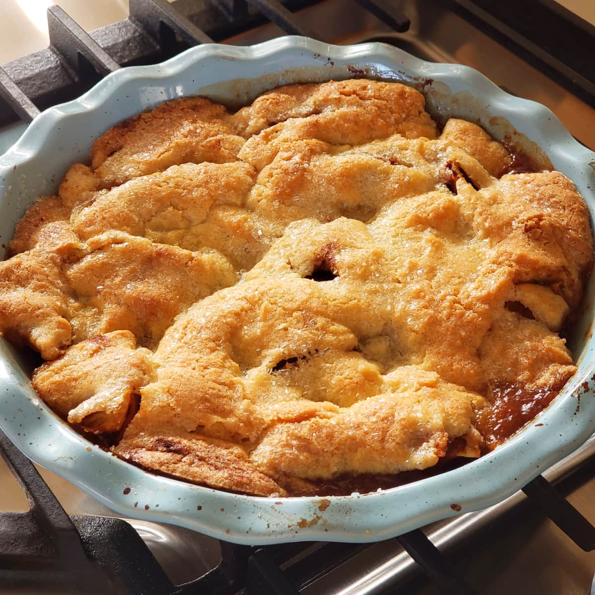 Swedish Apple Pie in a blue pie dish cooling on a rack