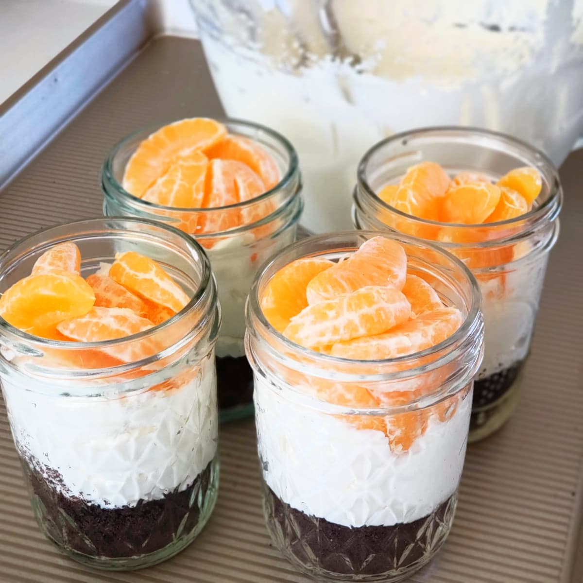 4 jars of Orange and Chocolate Cheesecake Pots on a baking tray